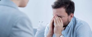 man with depression crying during psychotherapy session